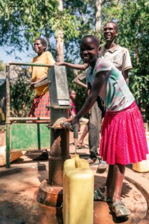 Mädchen an einem Brunnen in Uganda. Sauberes Trinkwasser hat hier das ALL4WASH Projekt von Viva con Agua ermöglicht